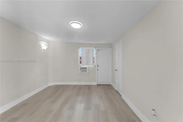 a view of a room with wooden floor and window
