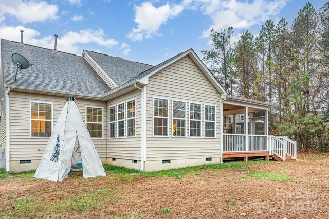 a view of a house with a yard and wooden fence