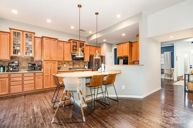 a kitchen with a table chairs refrigerator and cabinets