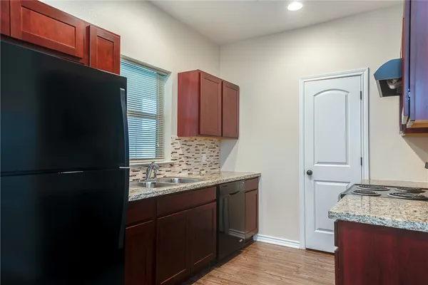 a kitchen with granite countertop stainless steel appliances and wooden cabinets