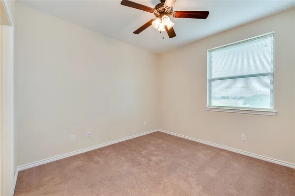 an empty room with a window and a fan