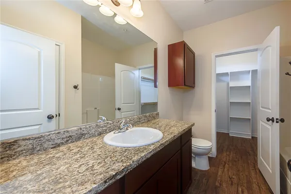 a bathroom with a granite countertop sink toilet and shower