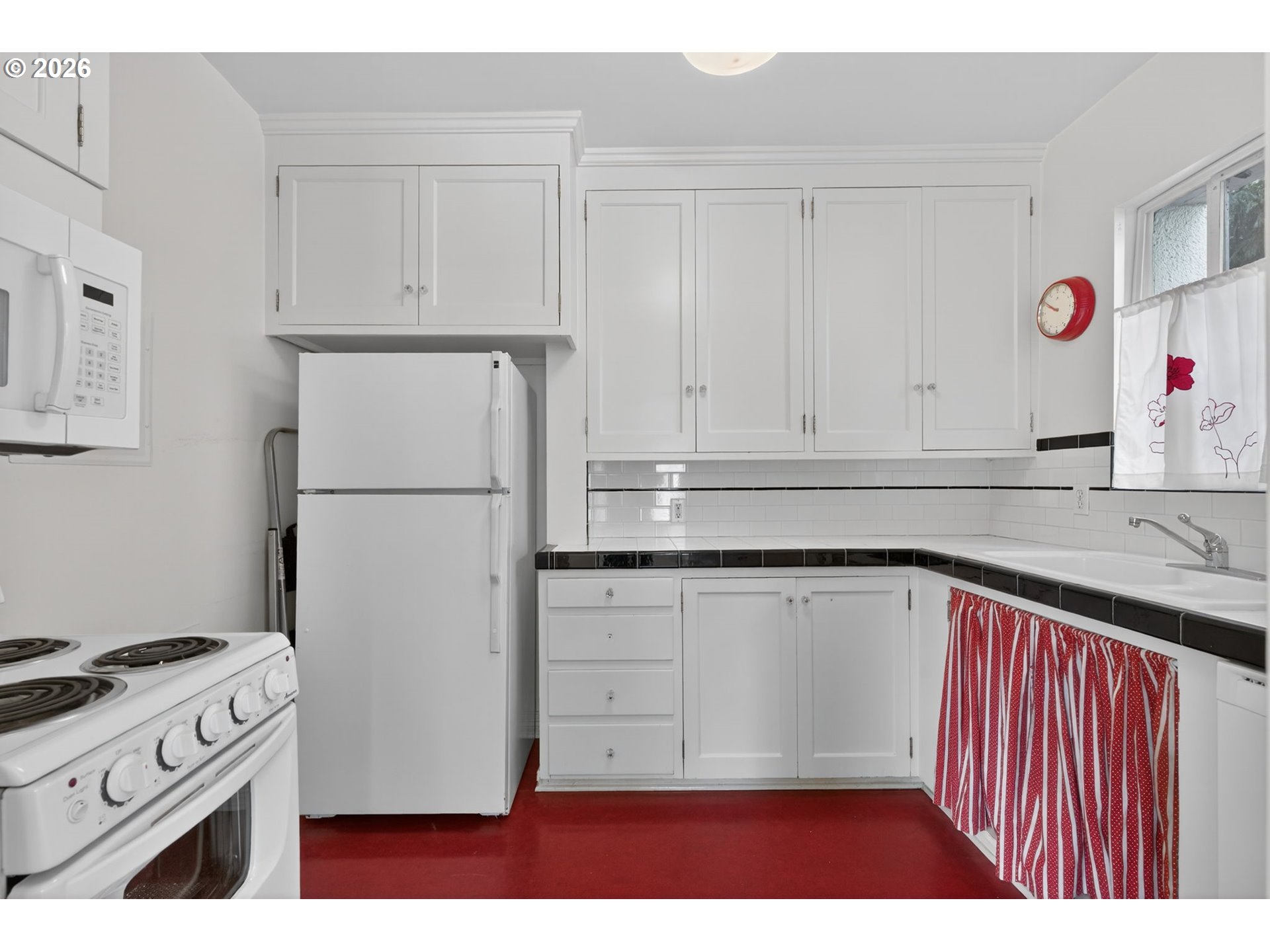 2325 Northeast Flanders Street, Unit 8 Portland, OR 97232 - Photo 13 of 42 a kitchen with granite countertop white cabinets and refrigerator