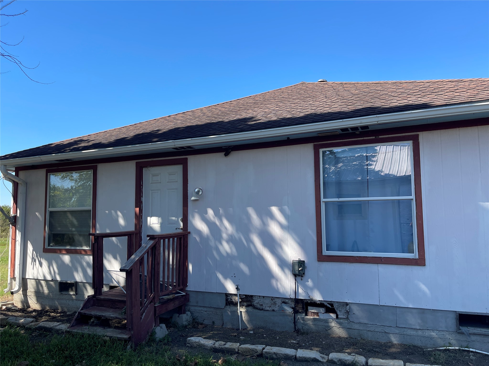 12212 Ballerstedt Road Elgin, TX 78621 - Photo 14 of 29 A classic shingle roof sits atop this single-story structure with a raised foundation.