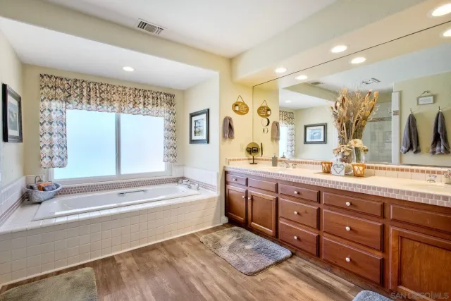 a bedroom with a bed flat screen tv and a chandelier