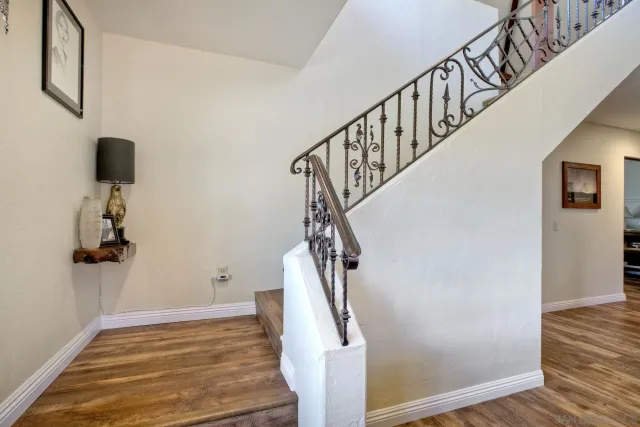 a view of a patio with table and chairs under an umbrella with a small yard