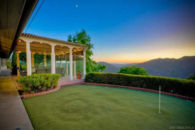 a view of a dry yard with mountains in the background