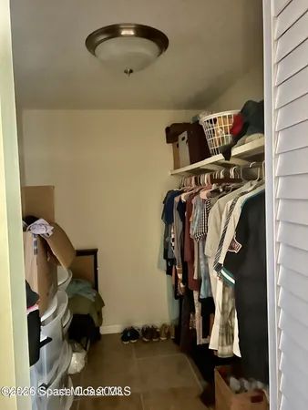 a view of walk in closet with clothes and shoes