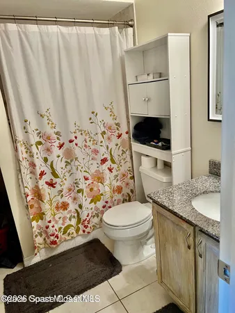 a bathroom with a granite countertop sink toilet and a mirror