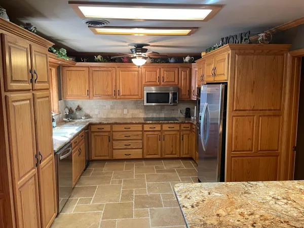 a kitchen with granite countertop a refrigerator and a sink