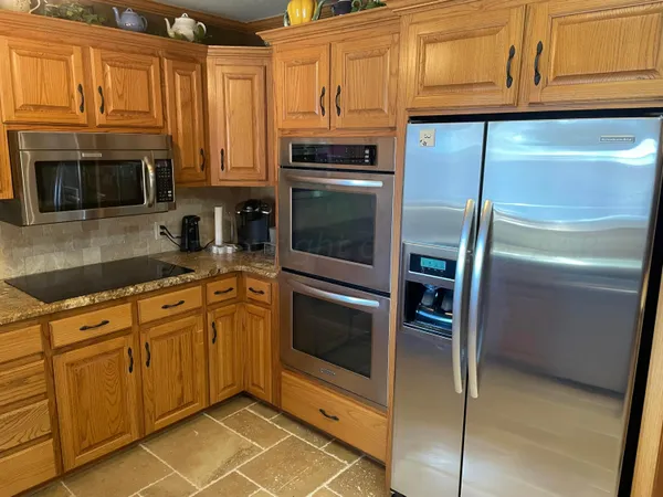 a kitchen with granite countertop stainless steel appliances and wooden cabinets