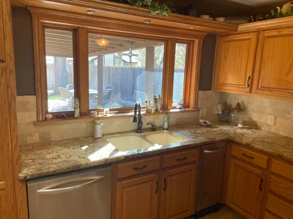 a bathroom with a granite countertop sink and a large mirror