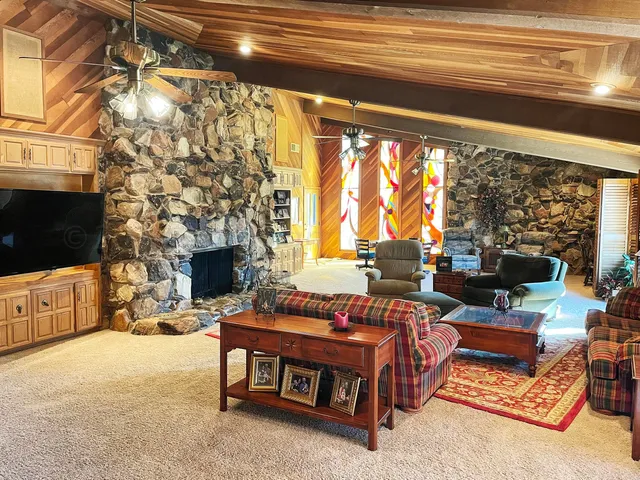 a living room with furniture a flat screen tv and a fireplace