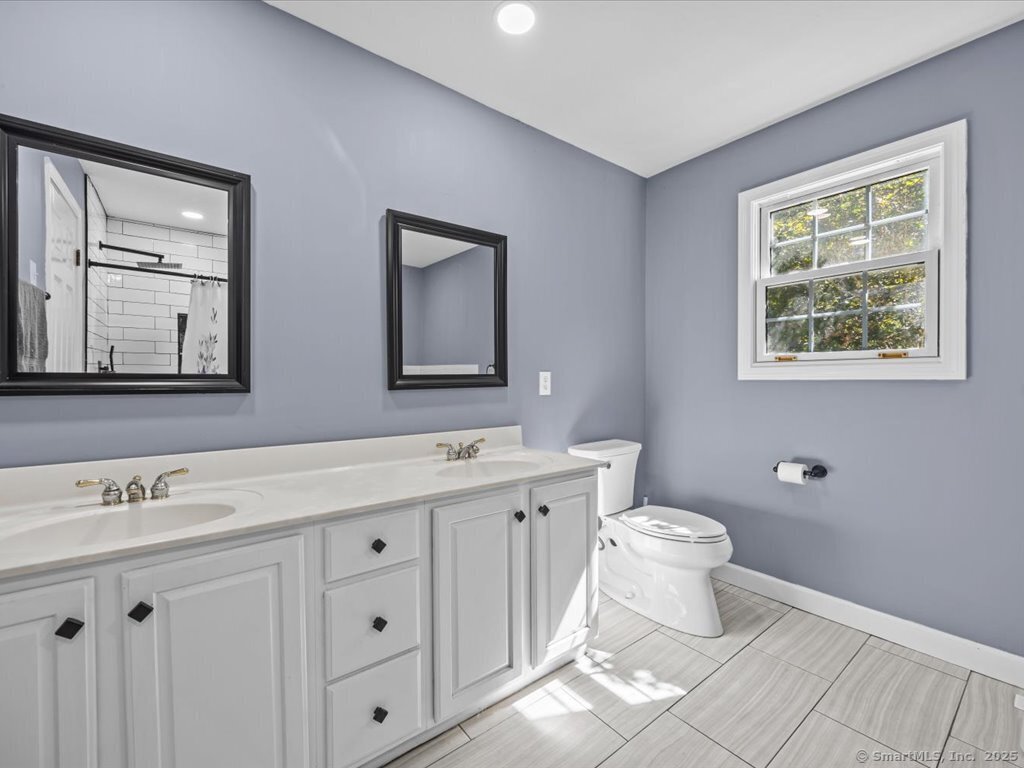 30 Renees Way Madison, CT 06443 - Photo 32 of 40 a bathroom with a toilet sink and mirror