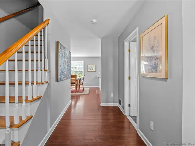 a view of a hallway with wooden floor and windows
