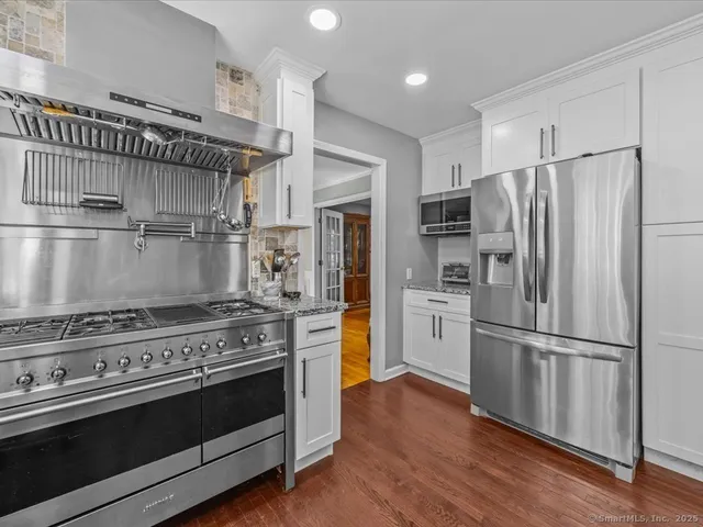 a kitchen with wooden floors and stainless steel appliances