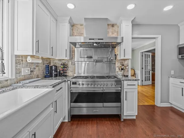a kitchen with stainless steel appliances granite countertop a stove and cabinets