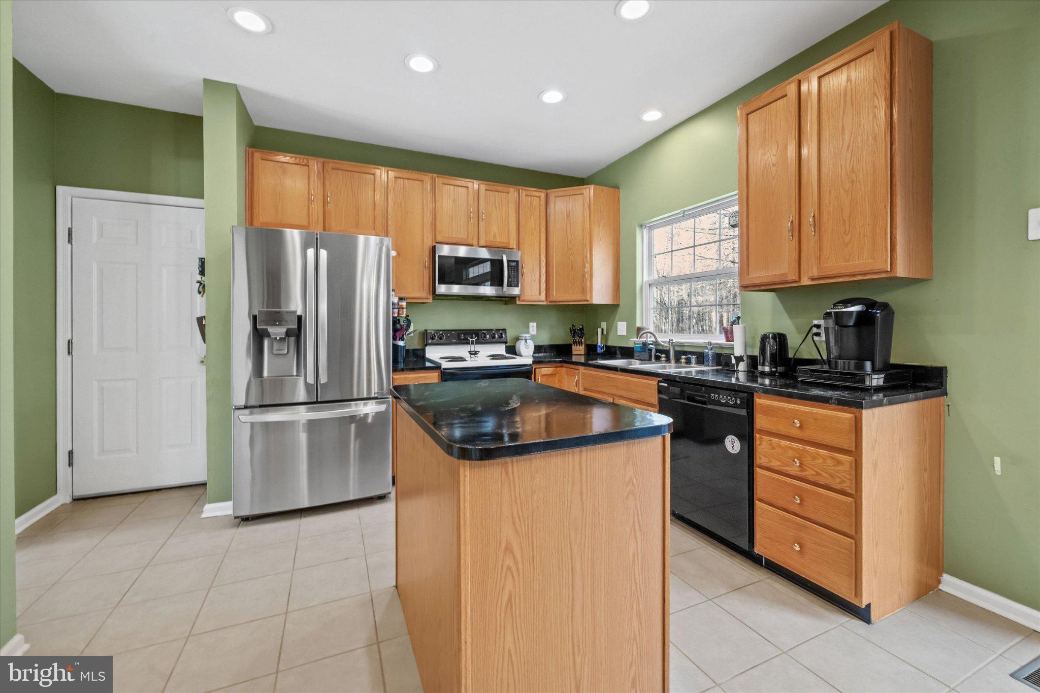 457 Preakness Run Newark, DE 19702 - Photo 32 of 55 a kitchen with stainless steel appliances granite countertop a refrigerator a stove a sink and a microwave
