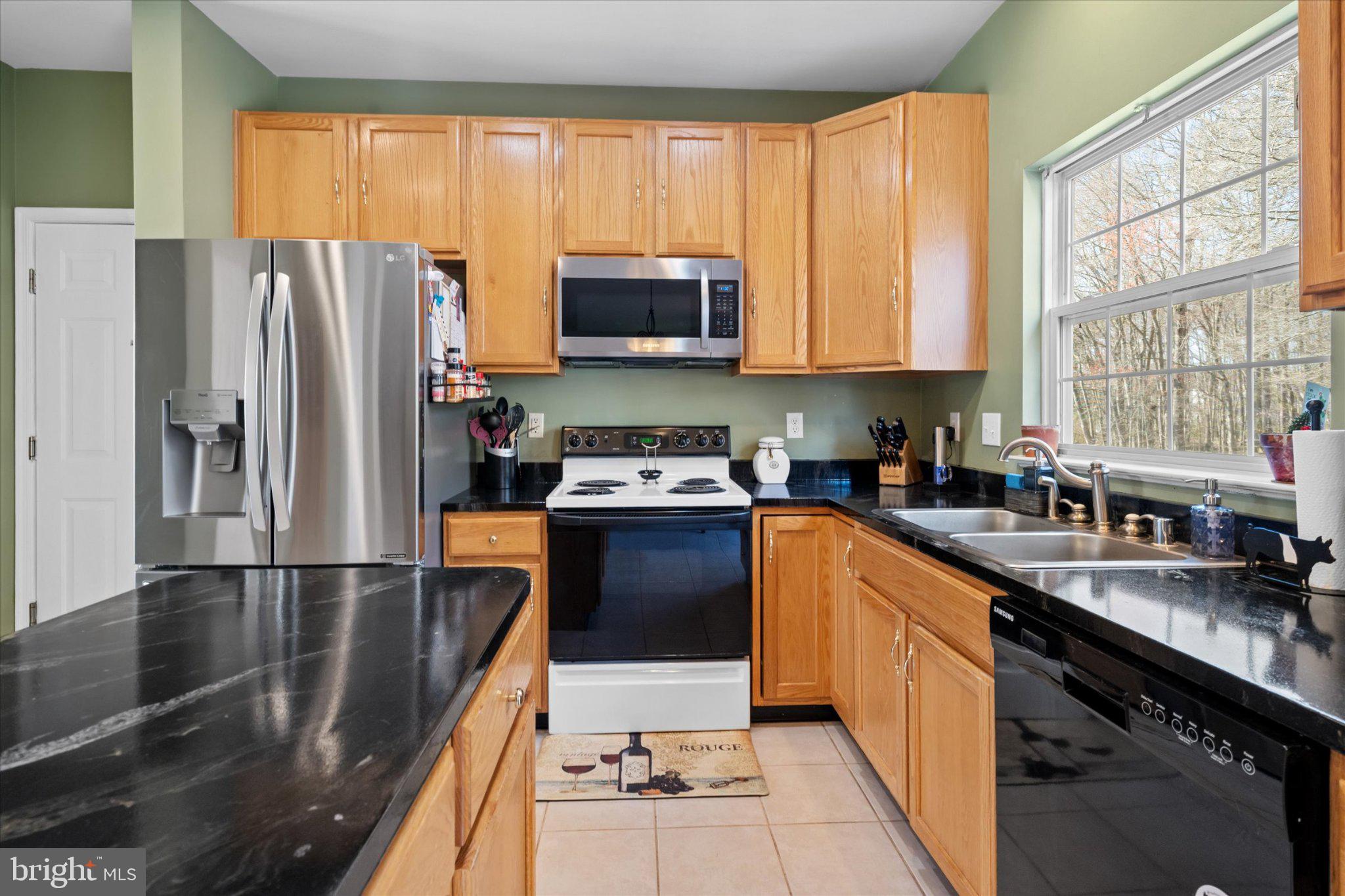 457 Preakness Run Newark, DE 19702 - Photo 33 of 55 a kitchen with granite countertop a refrigerator a sink a stove top oven and cabinets