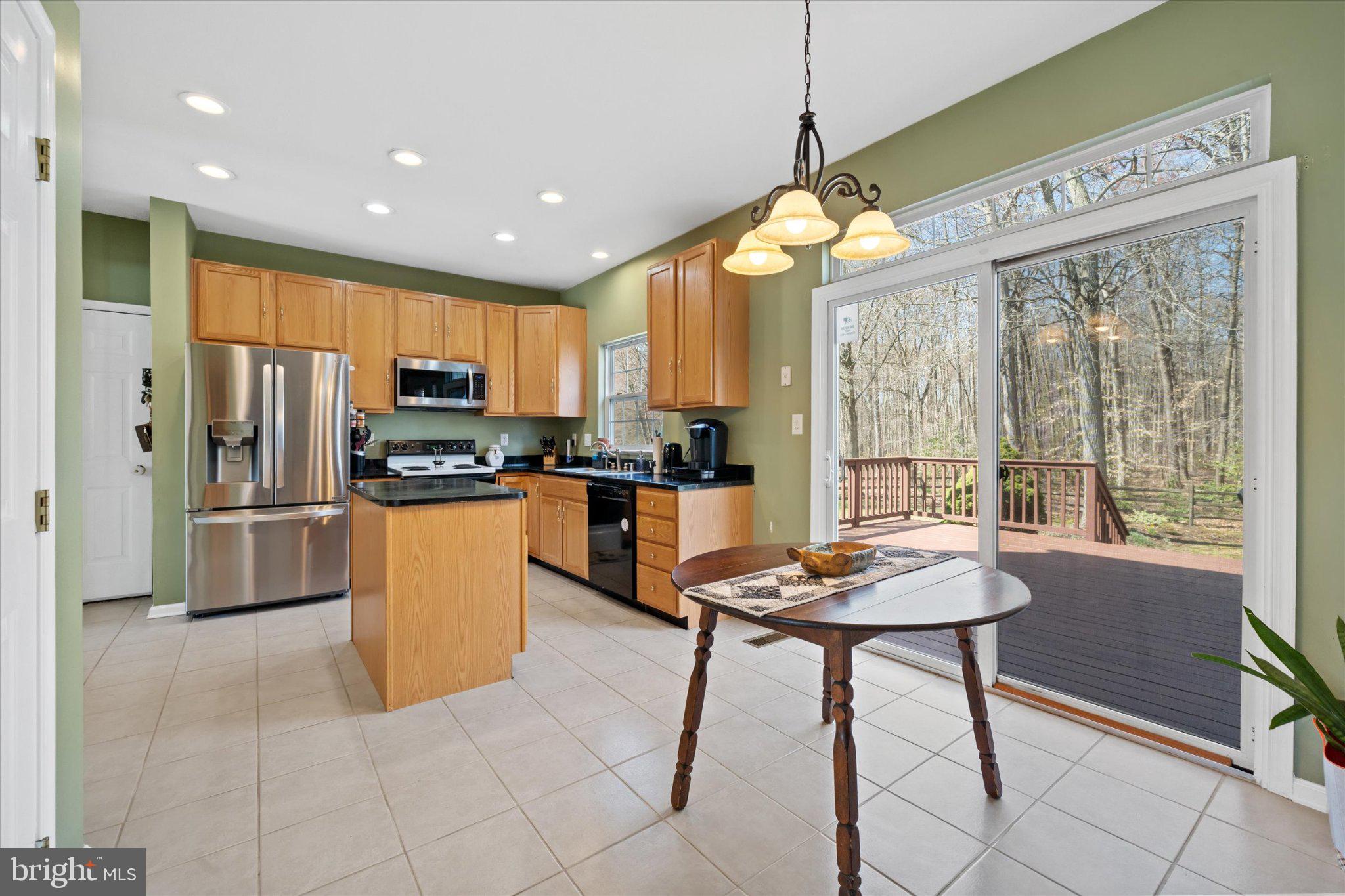 457 Preakness Run Newark, DE 19702 - Photo 37 of 55 a kitchen with stainless steel appliances kitchen island granite countertop a refrigerator a stove top oven a sink dishwasher and a dining table with wooden floor