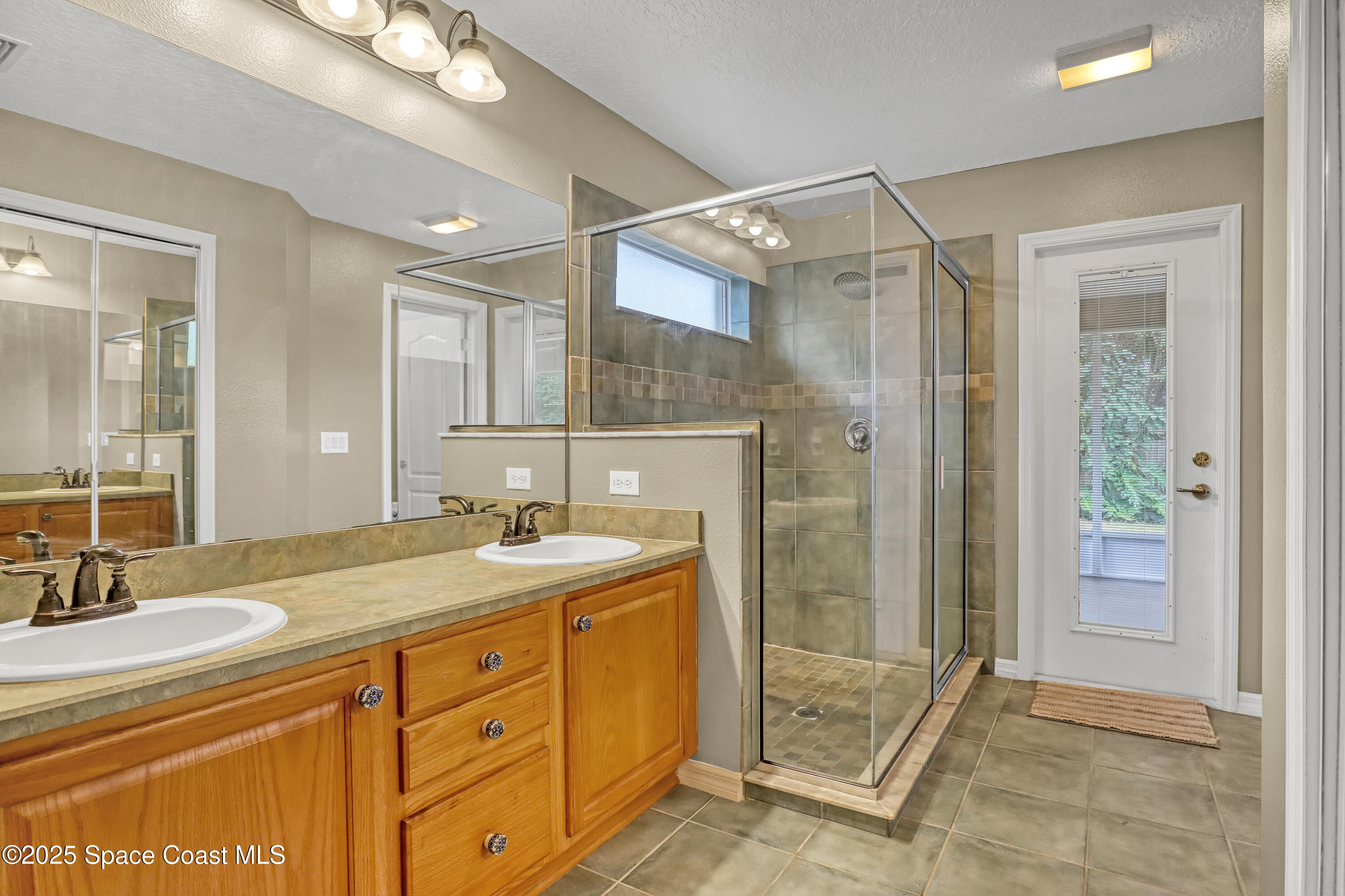 1081 Meadowbrook Road Northeast Palm Bay, FL 32905 - Photo 19 of 37 Primary bathroom with door to screened p