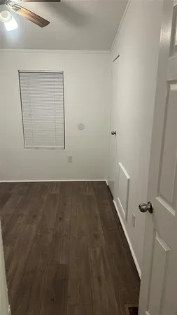an empty room with wooden floor and a white door
