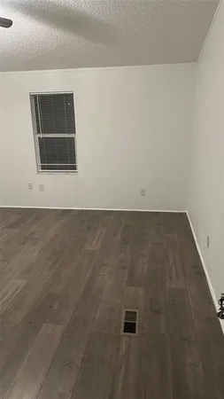 a view of a room with wooden floor and ceiling fan