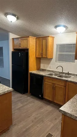 a kitchen with granite countertop a refrigerator and a sink