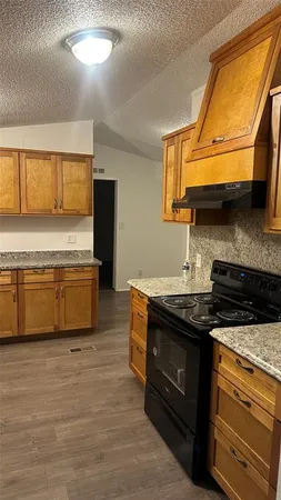 a kitchen with stainless steel appliances granite countertop a stove a sink and a microwave