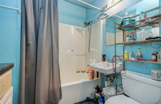 a bathroom with a sink a toilet a mirror and shower