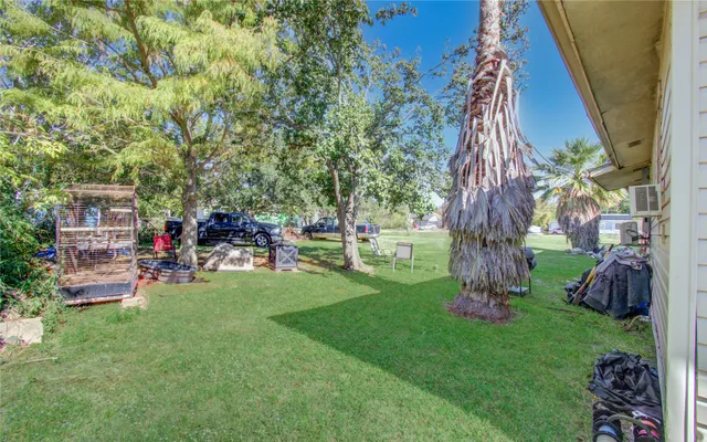 a view of backyard with table and chairs potted plants and a large tree