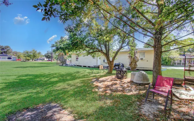 a view of a backyard with table and chairs and a fire pit