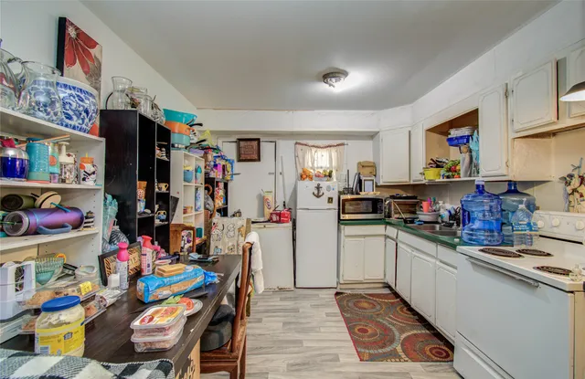 a kitchen filled with lots of clutter and stainless steel appliances
