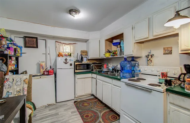 a kitchen with a sink cabinets and wooden floor
