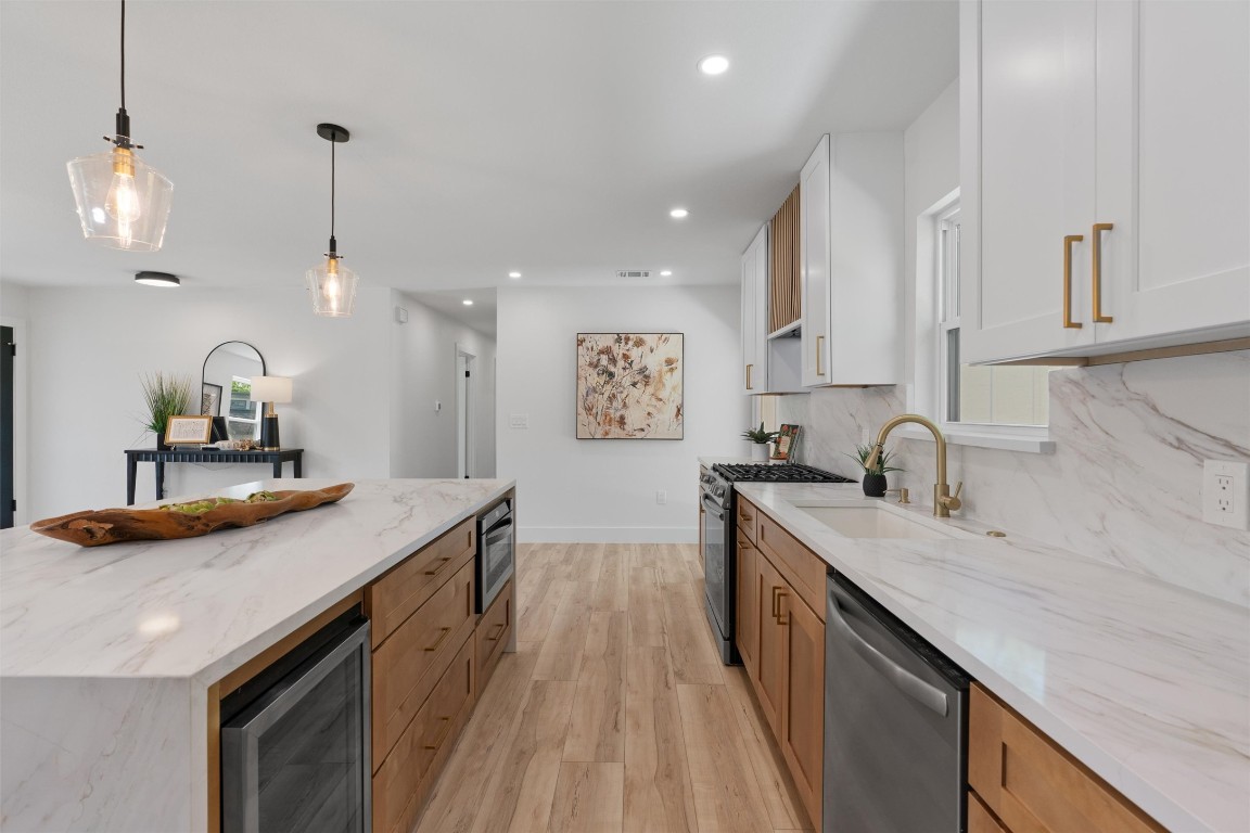 5604 Overbrook Drive Austin, TX 78723 - Photo 12 of 34 a kitchen with stainless steel appliances granite countertop a sink a stove and a wooden floors