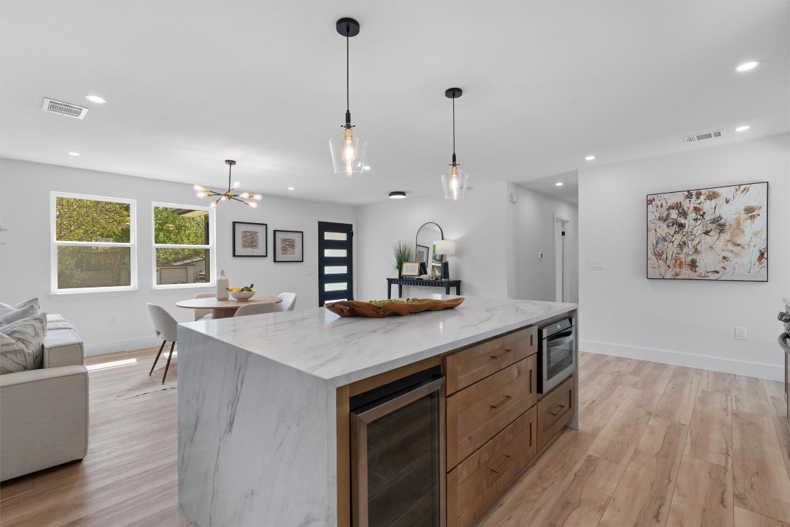 5604 Overbrook Drive Austin, TX 78723 - Photo 14 of 34 a kitchen with stainless steel appliances granite countertop a sink a stove a dining table and chairs with wooden floor
