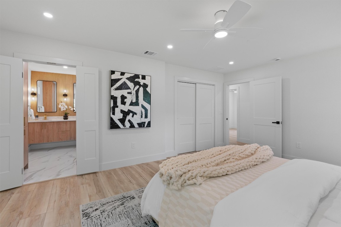 5604 Overbrook Drive Austin, TX 78723 - Photo 23 of 34 a bedroom with a large bed and a chandelier