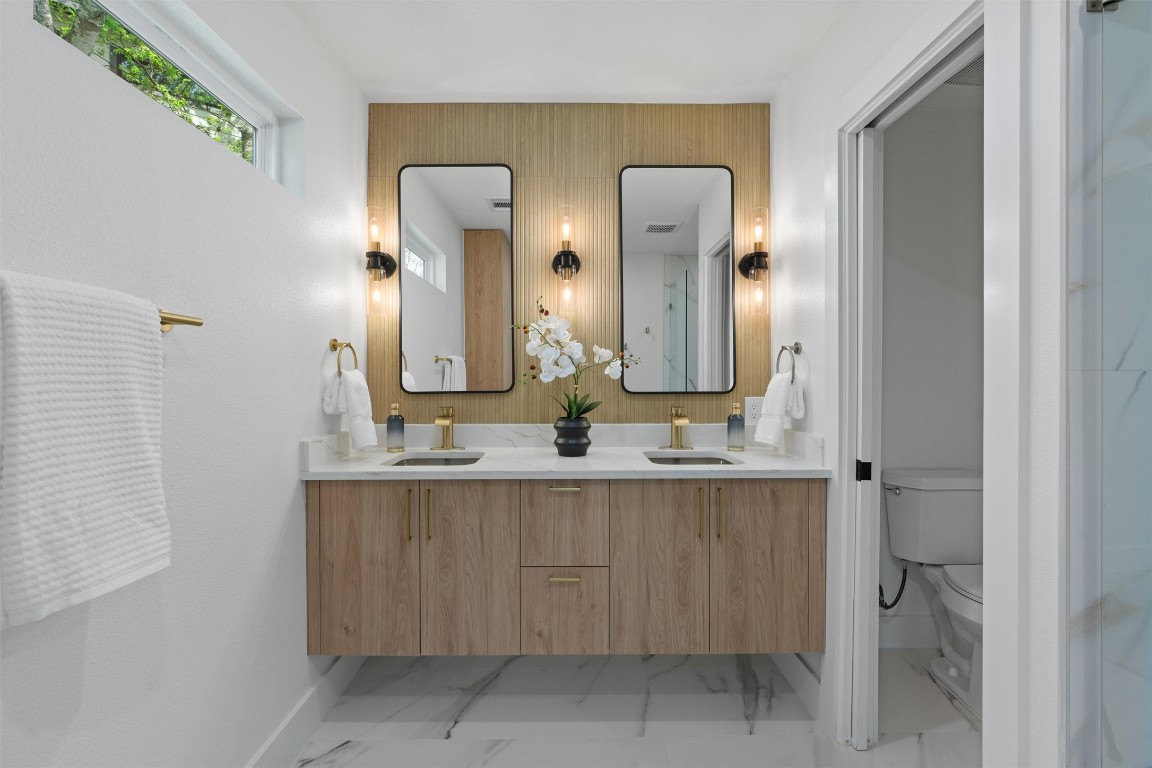 5604 Overbrook Drive Austin, TX 78723 - Photo 25 of 34 a bathroom with a double vanity sink and a mirror