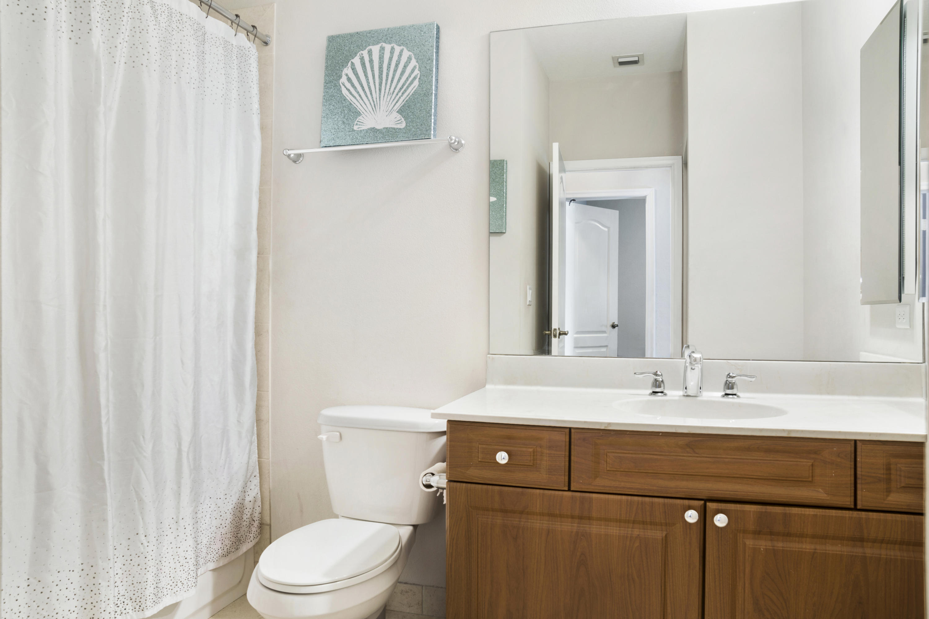 4719 North Prive Circle Delray Beach, FL 33445 - Photo 18 of 23 a bathroom with a sink a toilet and a mirror