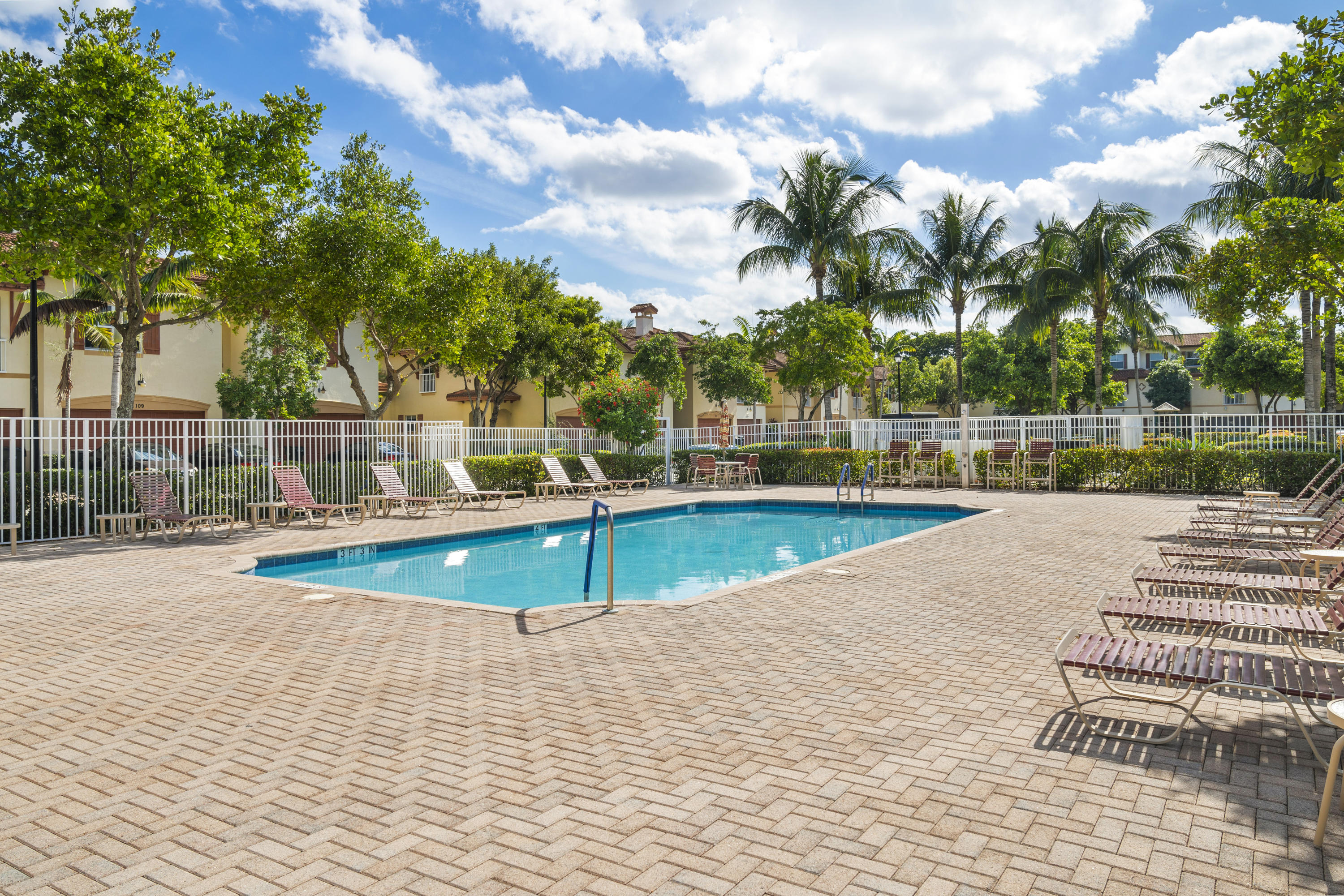 4719 North Prive Circle Delray Beach, FL 33445 - Photo 21 of 23 a view of a swimming pool with a yard and palm trees
