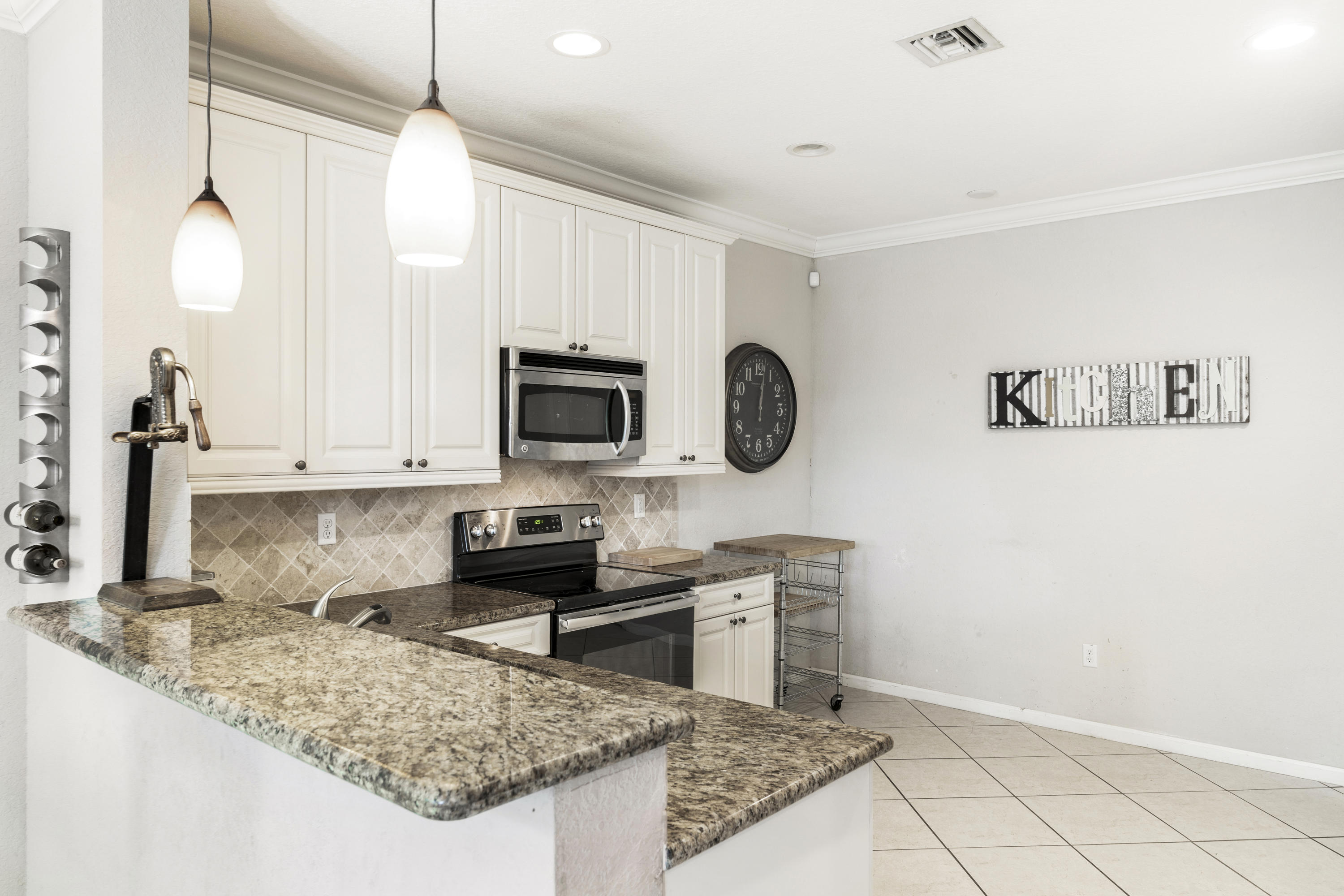 4719 North Prive Circle Delray Beach, FL 33445 - Photo 5 of 23 a kitchen with stainless steel appliances granite countertop a stove a microwave and a sink