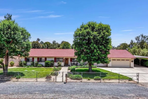 a view of house with a yard and sitting area