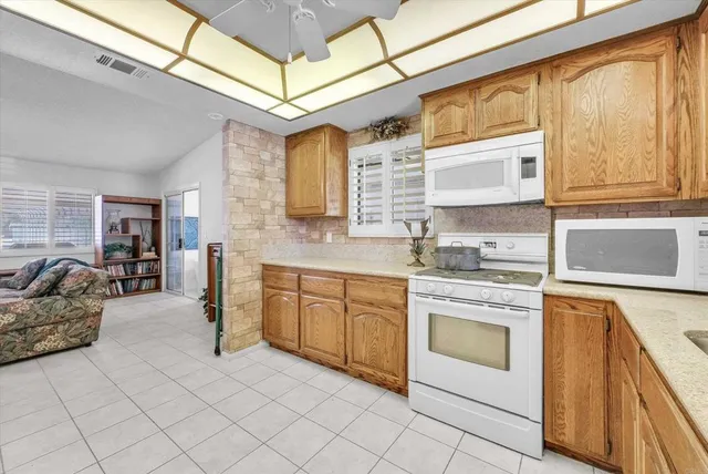 a kitchen with white cabinets and appliances