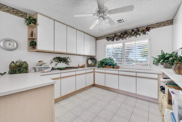 a kitchen with cabinets and chairs