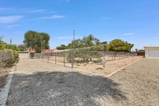 aerial view of a house with a yard and large trees