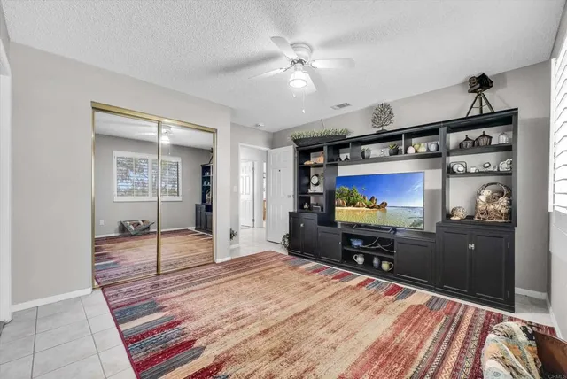 a view of a bedroom with wooden floor and a ceiling fan