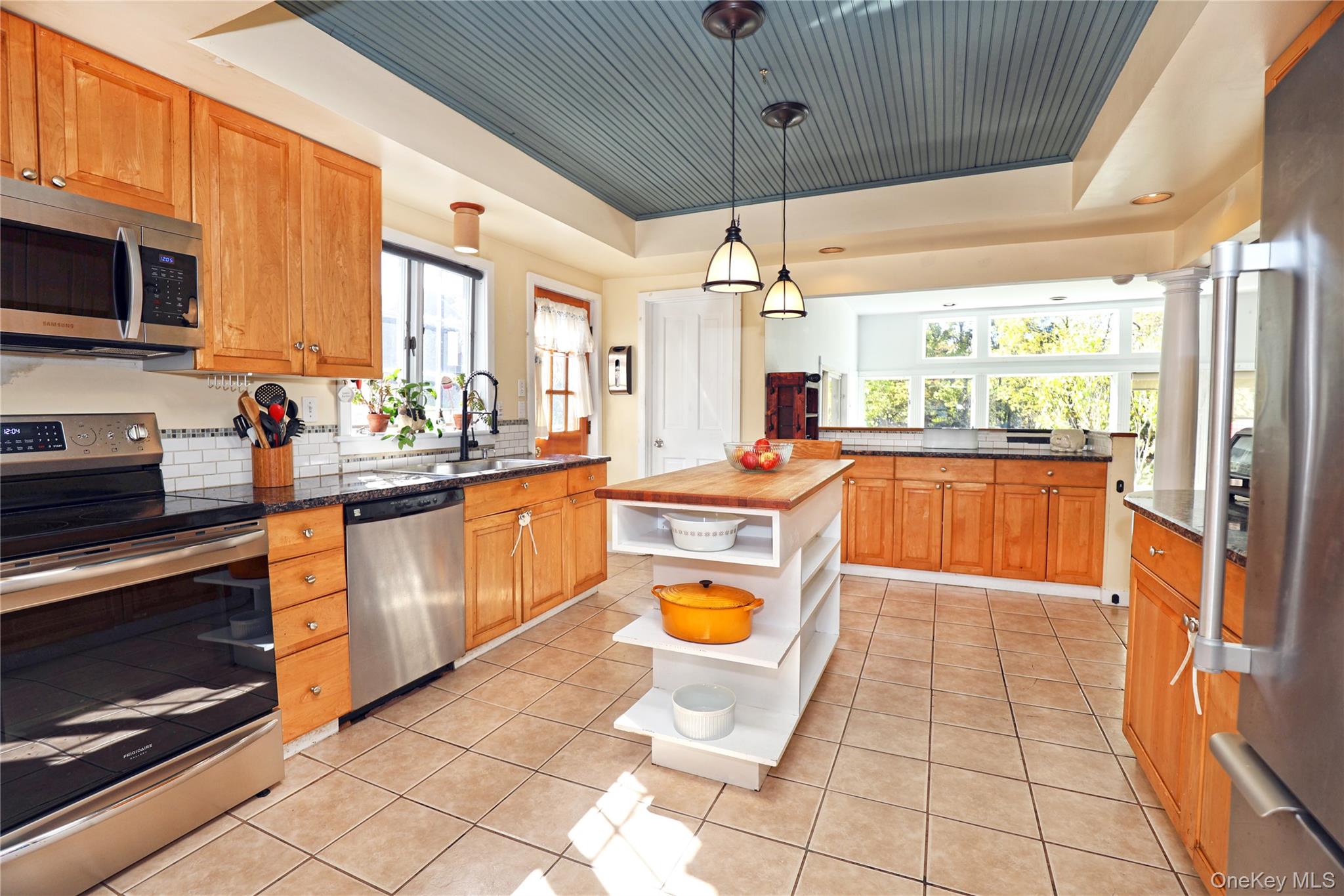 92 Hughson Road Carmel, NY 10512 - Photo 7 of 42 Kitchen with a tray ceiling, appliances with stainless steel finishes, light tile patterned flooring, and dark stone counters