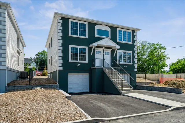 a view of a brick house with many windows and plants