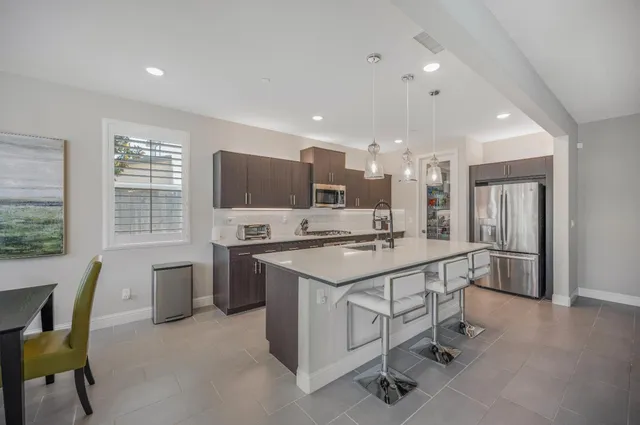 a kitchen with a dining table chairs appliances and cabinets