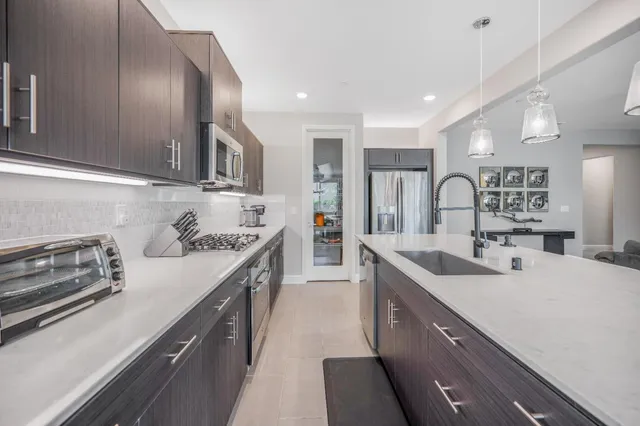 a kitchen with stainless steel appliances granite countertop a sink stove and cabinets
